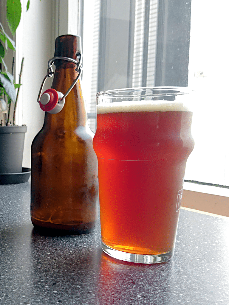 Halvlitersflaske fra Ahornberger Brauerei, sammen med et glass ravfarget øl.